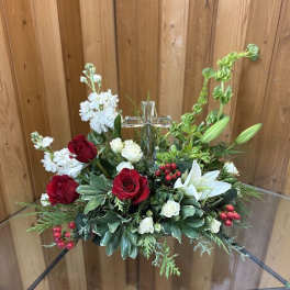 Red and white floral arrangement with a glass cross in the center