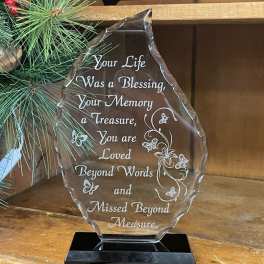 Clear memorial plaque on a black base with engraved sympathy message