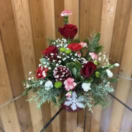 Red roses and carnations in a festive holiday arrangement