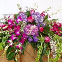 Large pink and purple floral arrangement with cascading blooms