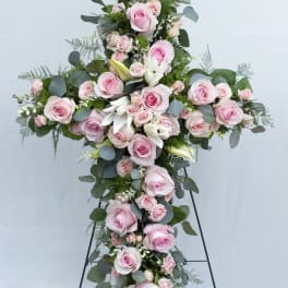 Tall cross-shaped floral spray with pink roses and white lilies