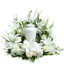 White floral arrangement with lilies, roses, and a white urn vase
