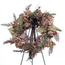 Circular wreath with dried hydrangeas and roses on a stand