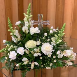 White floral arrangement with a clear cross centerpiece