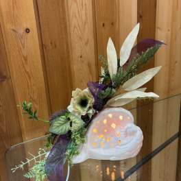 Decorative ceramic snail with a floral accent and purple ribbon