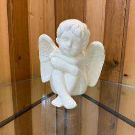 White ceramic angel figurine sitting with wings spread