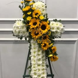 Cross-shaped floral tribute with yellow sunflowers and white chrysanthemums