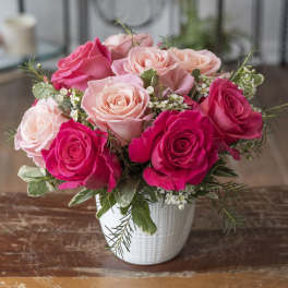 Pink and blush roses arranged in a white vase