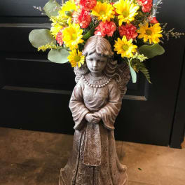Flower arrangement on a girl statue with yellow and red blooms