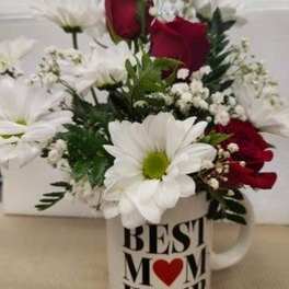 Red roses and white daisies arranged in a "Best Mom Ever" mug.