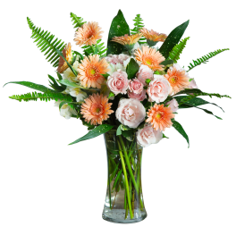 Peach gerbera daisies and pale pink roses in a clear glass vase