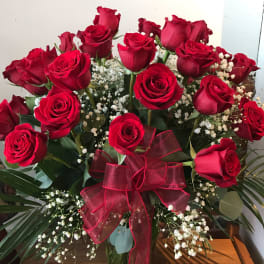Bouquet of red roses with baby's breath in a glass vase