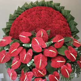 Large red floral wreath with red anthuriums and green foliage