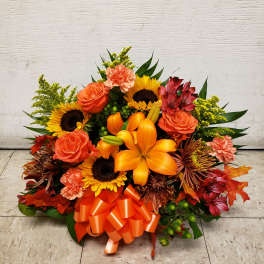 Orange and yellow mixed bouquet with roses, lilies, sunflowers, and a ribbon bow