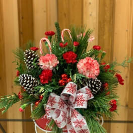 Christmas arrangement with pinecones, candy canes, and a snowflake ribbon