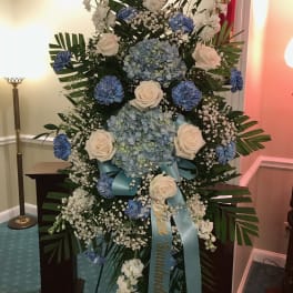 Large blue and white funeral spray with roses and hydrangeas