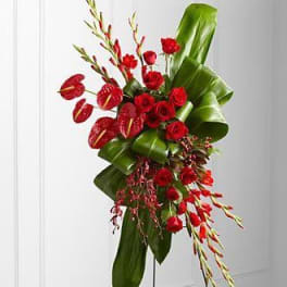 Tall red floral arrangement with large green leaves