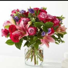 Bouquet of pink and purple flowers in a clear glass vase