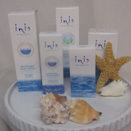 Innis skincare boxes arranged with seashells and a starfish on a round display