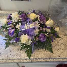 Purple and white rose bouquet with a lavender ribbon and "Mom" sign
