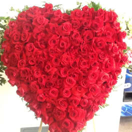 Heart-shaped arrangement of red roses on a stand