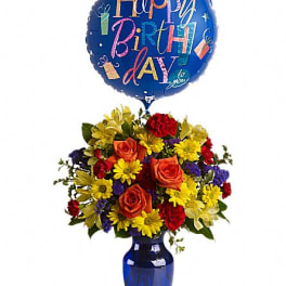 Birthday bouquet with a blue balloon and mixed flowers in a blue vase