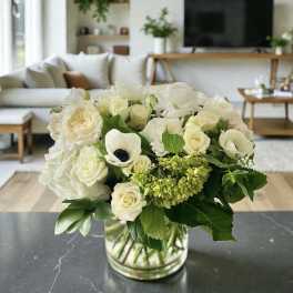 White floral bouquet in a clear glass vase on a table