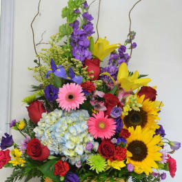Colorful mixed flower arrangement in a woven basket