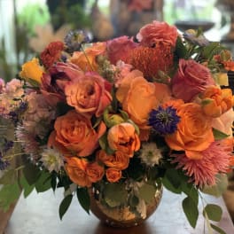 Bright orange and pink bouquet in a glass vase