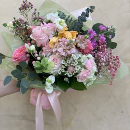 Hand-tied bouquet of pink, white, and yellow flowers with eucalyptus