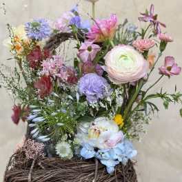 Mixed pastel flower arrangement in a woven basket