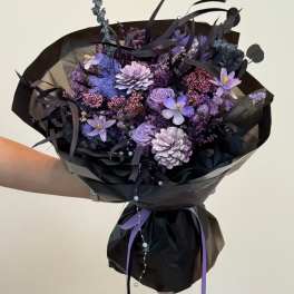 Purple bouquet wrapped in black paper with ribbon