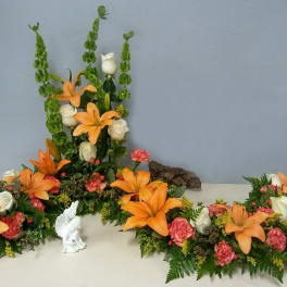 Orange lilies and white roses arranged in a floral display