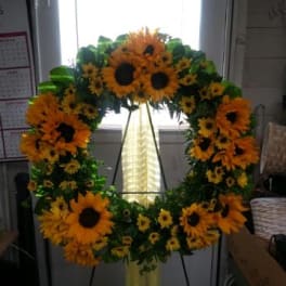 Large sunflower wreath on a stand with a yellow ribbon