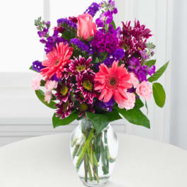 Bouquet of pink and purple flowers in a clear glass vase