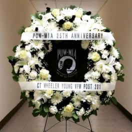 White funeral wreath with ribbons and a POW-MIA tribute center