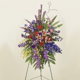 Tall standing floral spray with red, purple, and pink blooms on an easel