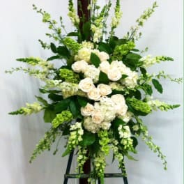 Tall white and green floral standing arrangement on an easel
