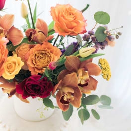 Bouquet of orange and red flowers in a white vase