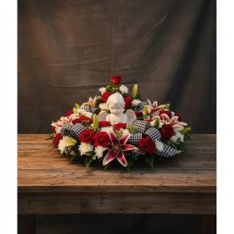 Red and white floral arrangement with a white angel figurine in the center