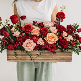 Long wooden box arrangement of red and blush roses
