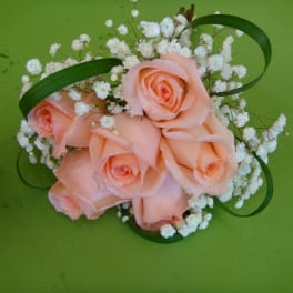 Peach roses with white baby's breath on a green background