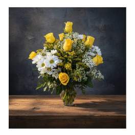 Yellow roses and white daisies arranged in a clear glass vase
