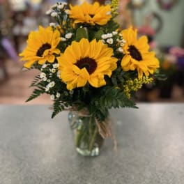 Bouquet of yellow sunflowers in a clear glass vase