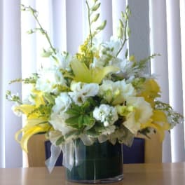 Yellow and white floral arrangement in a glass vase