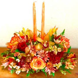 Autumn floral centerpiece with two tall orange candles