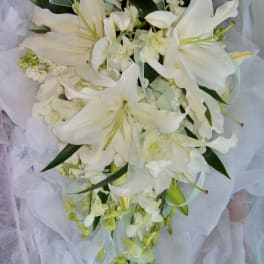 White lily bouquet with ribbon and tissue wrap