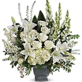 White lilies and roses arranged in a gray vase