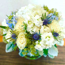 Bouquet of white and pale blue flowers in a glass vase