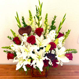 Red roses and white lilies in a woven basket arrangement